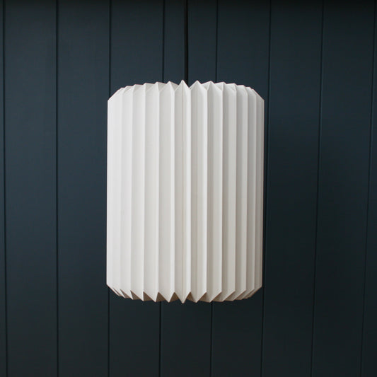 Paper light pendant hanging from the kitchen ceiling, pickle-shaped providing lovely warm light. Comes folded